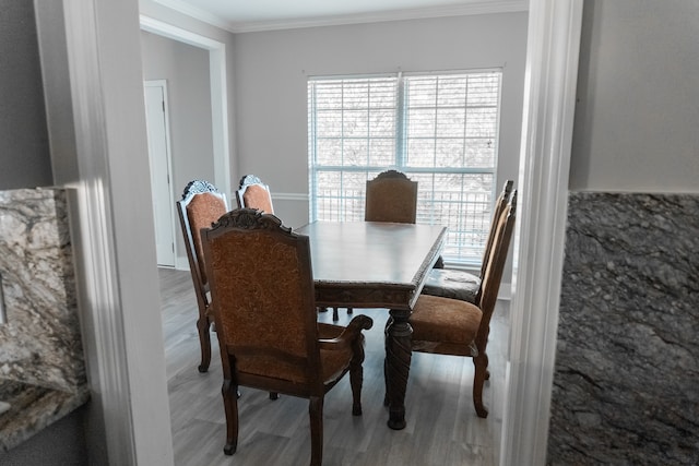 dining space with ornamental molding and hardwood / wood-style floors