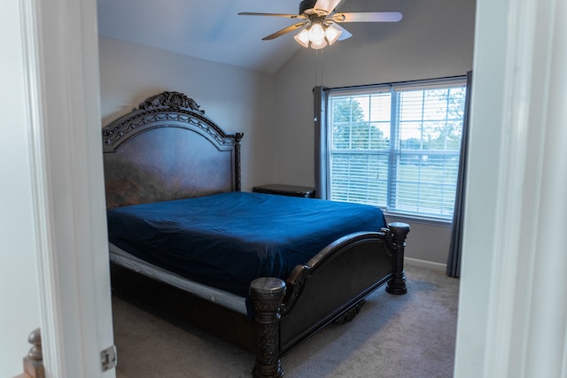 carpeted bedroom with ceiling fan and vaulted ceiling