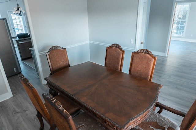 dining space with a notable chandelier, plenty of natural light, and dark hardwood / wood-style floors