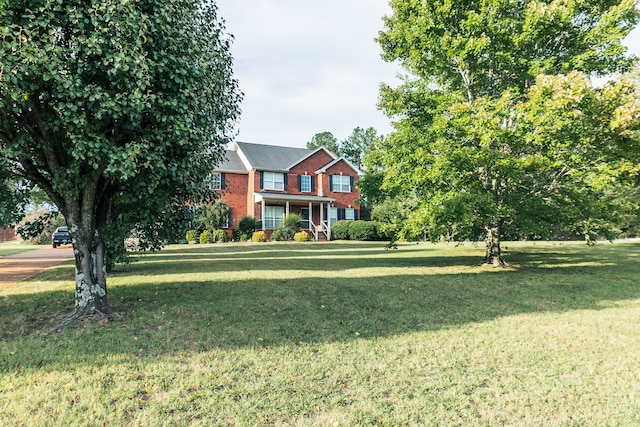 colonial inspired home featuring a front lawn