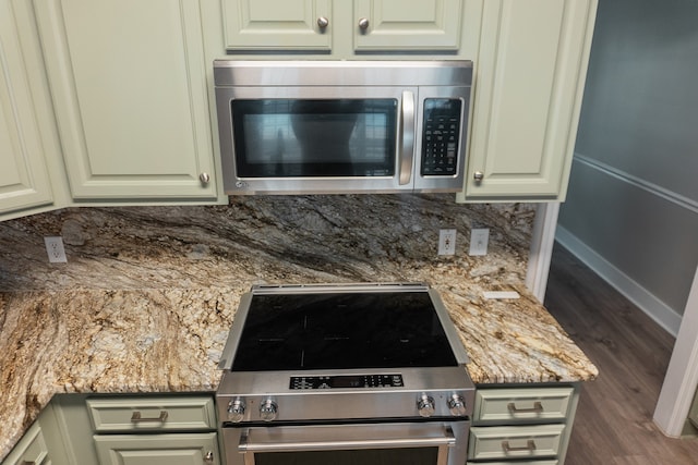 kitchen featuring light stone countertops, hardwood / wood-style floors, appliances with stainless steel finishes, and backsplash