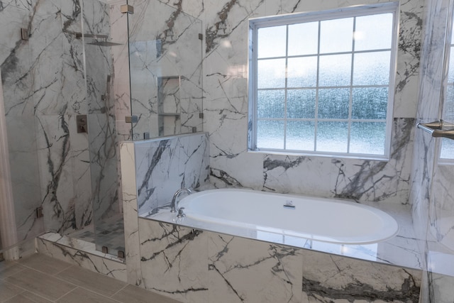 bathroom featuring plenty of natural light, tile walls, and shower with separate bathtub