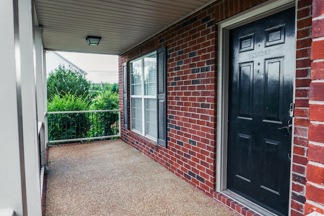 view of exterior entry featuring covered porch