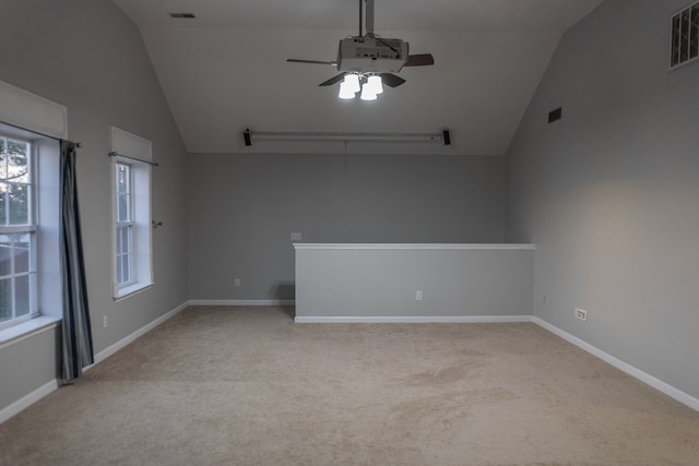 empty room with light carpet, lofted ceiling, and ceiling fan