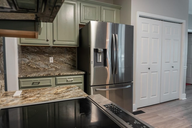 101 Brookstone Dr, Burns, TN 37029 - kitchen with decorative backsplash, wood finished floors, stone countertops, stainless steel refrigerator with ice dispenser, and green cabinetry