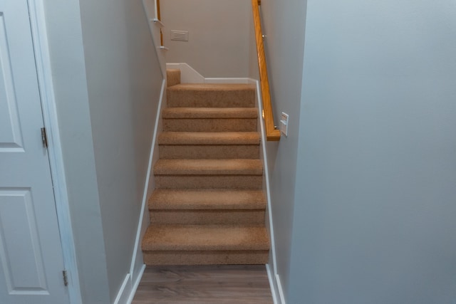 stairs featuring wood-type flooring