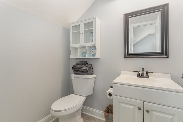 bathroom featuring a textured ceiling, toilet, tile patterned floors, lofted ceiling, and vanity