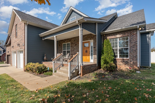 view of front of property featuring a porch, a front yard, and a garage