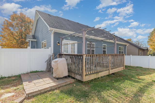 back of house featuring a patio, a deck, a lawn, and a pergola