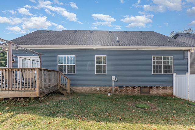 rear view of property featuring a yard and a deck