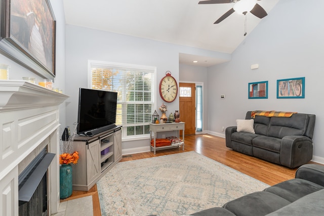 living room featuring lofted ceiling, light wood-type flooring, and ceiling fan