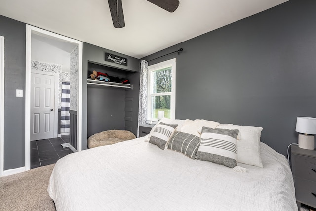 carpeted bedroom featuring ceiling fan and ensuite bathroom