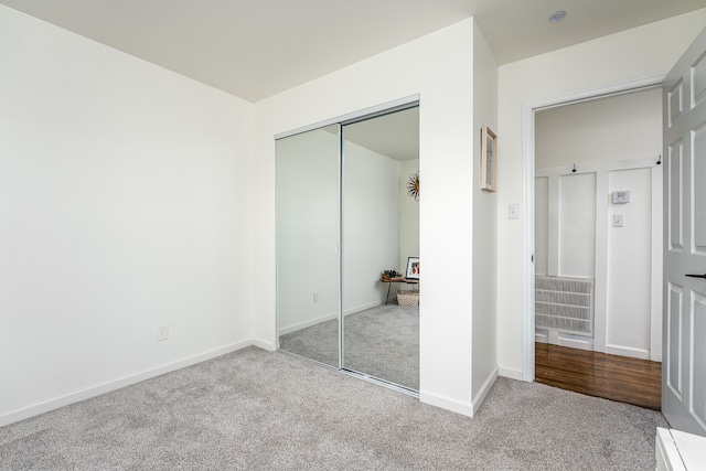 unfurnished bedroom featuring a closet and light carpet