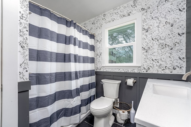 bathroom with toilet, vanity, and tile patterned flooring