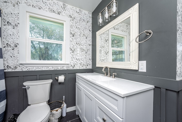 bathroom featuring vanity, tile patterned flooring, a healthy amount of sunlight, and toilet