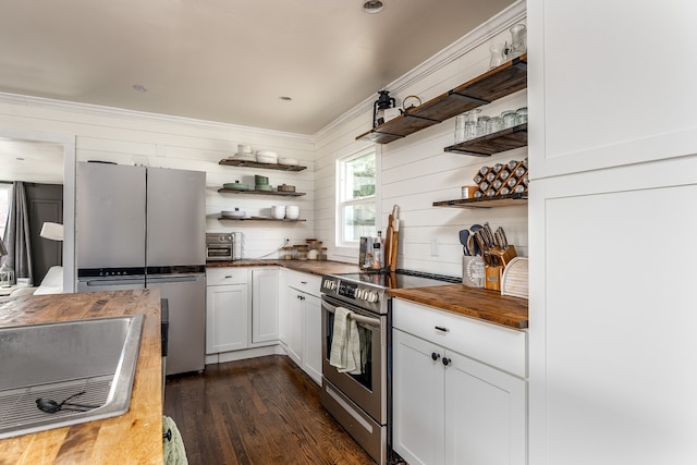 kitchen featuring stainless steel appliances, ornamental molding, white cabinets, wood counters, and dark wood-type flooring