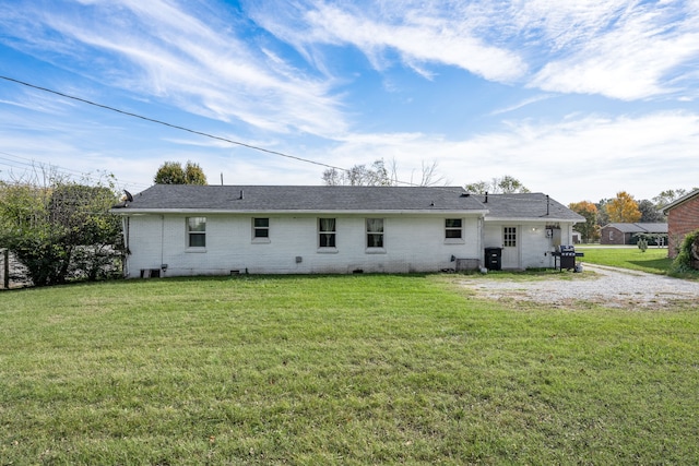 rear view of property featuring a lawn