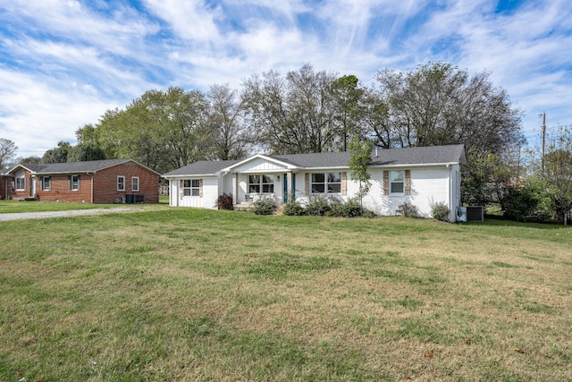 ranch-style home featuring central air condition unit and a front yard