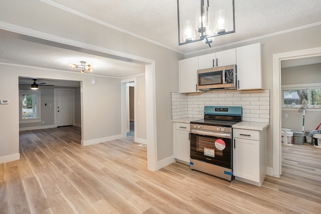 kitchen featuring a healthy amount of sunlight, stainless steel appliances, light wood-type flooring, and white cabinets