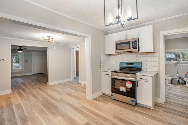 1828 S Main St, Columbia, TN 38401 - kitchen featuring appliances with stainless steel finishes, a textured ceiling, a chandelier, light countertops, and light wood finished floors