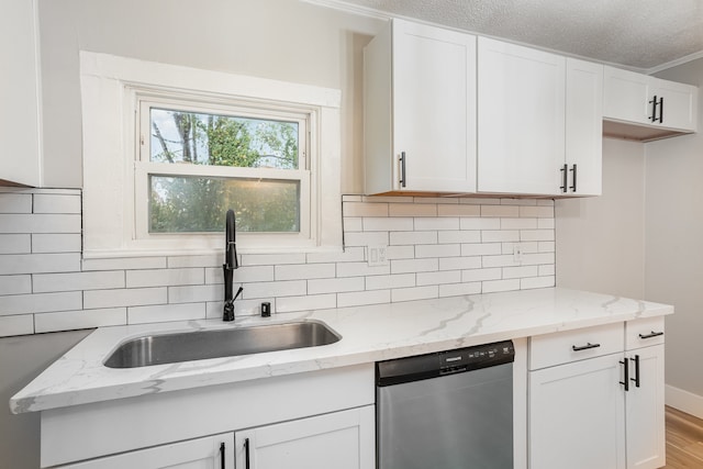 kitchen with backsplash, sink, stainless steel dishwasher, and white cabinets