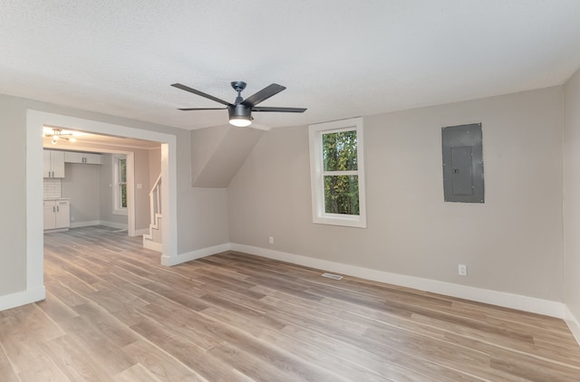 bonus room with light hardwood / wood-style flooring, a textured ceiling, electric panel, and ceiling fan