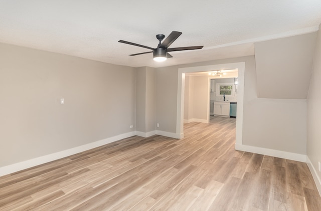 empty room with light hardwood / wood-style floors, a textured ceiling, sink, and ceiling fan