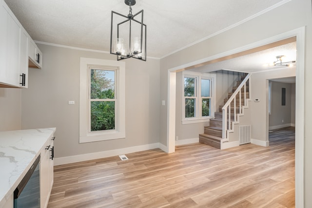 unfurnished dining area featuring a textured ceiling, ornamental molding, light wood-type flooring, and beverage cooler