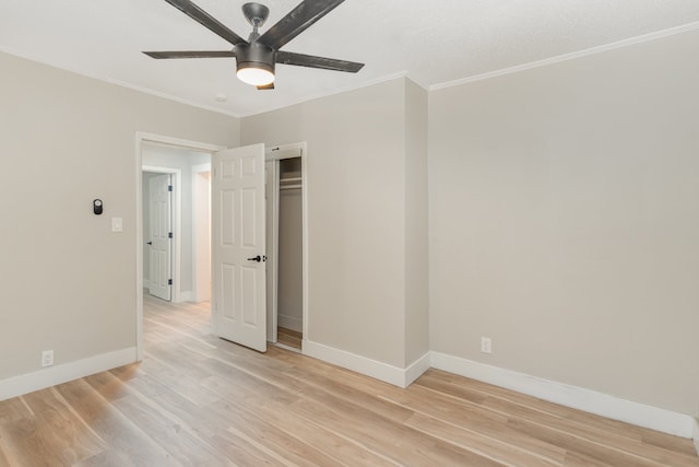 empty room with ceiling fan, crown molding, and light hardwood / wood-style flooring