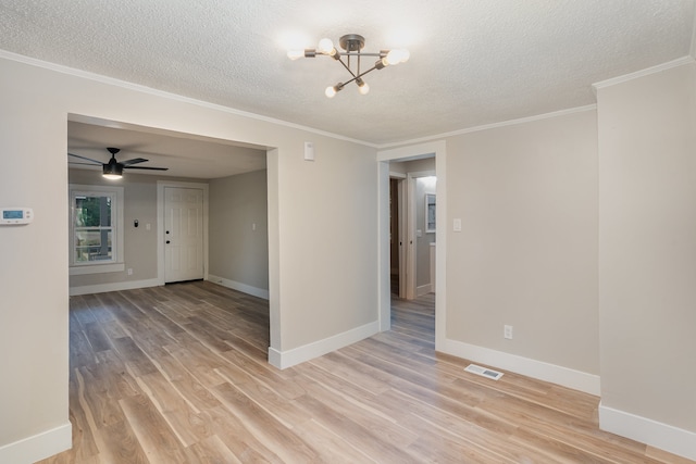 spare room featuring a textured ceiling, ornamental molding, light wood-type flooring, and ceiling fan with notable chandelier