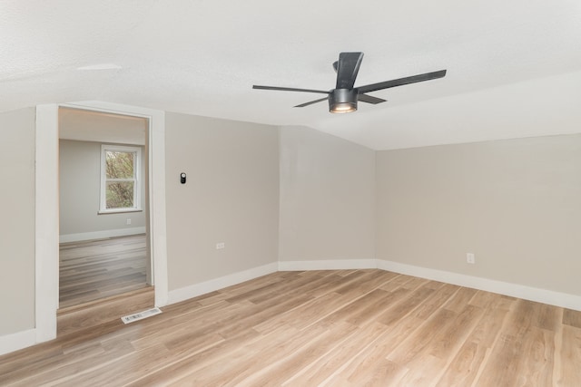 unfurnished room featuring lofted ceiling, a textured ceiling, light wood-type flooring, and ceiling fan