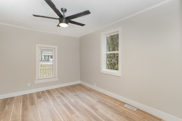 spare room with ceiling fan, a textured ceiling, light hardwood / wood-style floors, and plenty of natural light