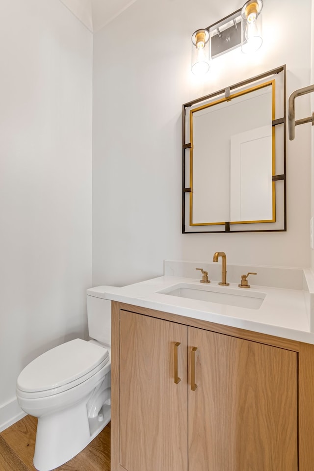 bathroom with vanity, toilet, and hardwood / wood-style floors