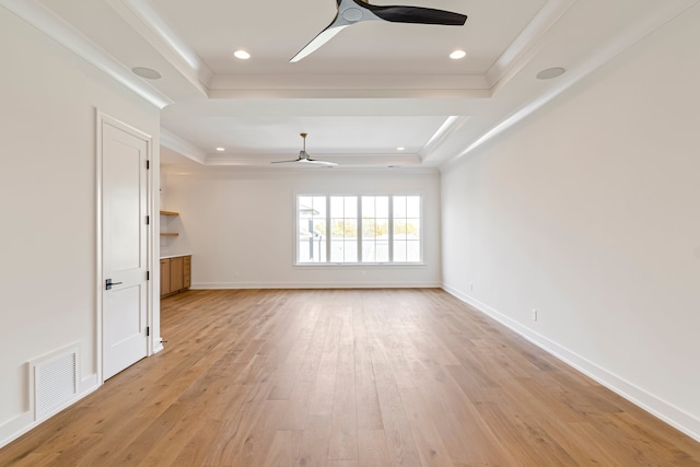 unfurnished living room featuring crown molding, ceiling fan, a raised ceiling, and light hardwood / wood-style flooring