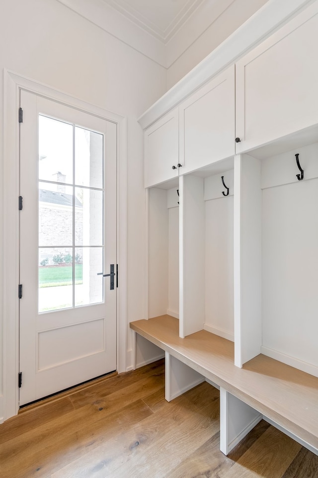 mudroom with crown molding and light hardwood / wood-style floors