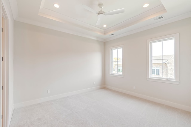 carpeted empty room with ceiling fan, ornamental molding, and a tray ceiling