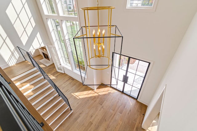 foyer featuring a high ceiling, light hardwood / wood-style flooring, and a notable chandelier