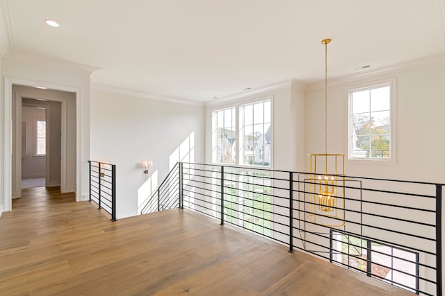 hallway featuring a notable chandelier, crown molding, and wood-type flooring