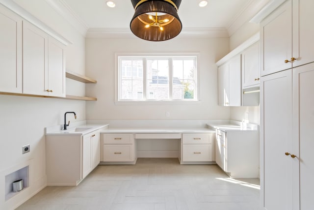 laundry room with crown molding, cabinets, hookup for an electric dryer, and sink