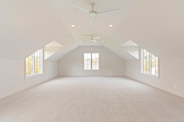 additional living space featuring vaulted ceiling, light carpet, and ceiling fan