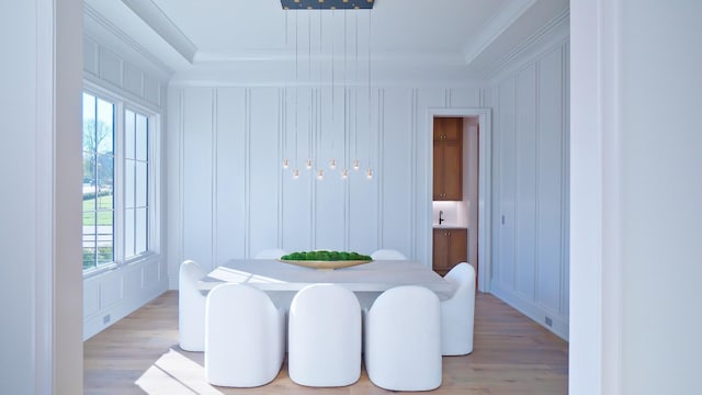 dining area with crown molding and light hardwood / wood-style floors