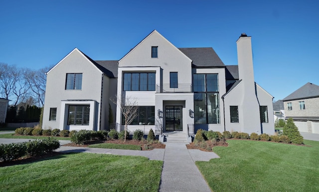 view of front facade with a balcony and a front lawn