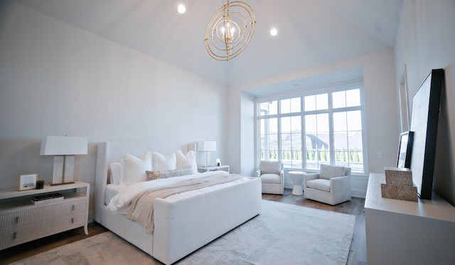 bedroom featuring lofted ceiling, hardwood / wood-style floors, and a chandelier