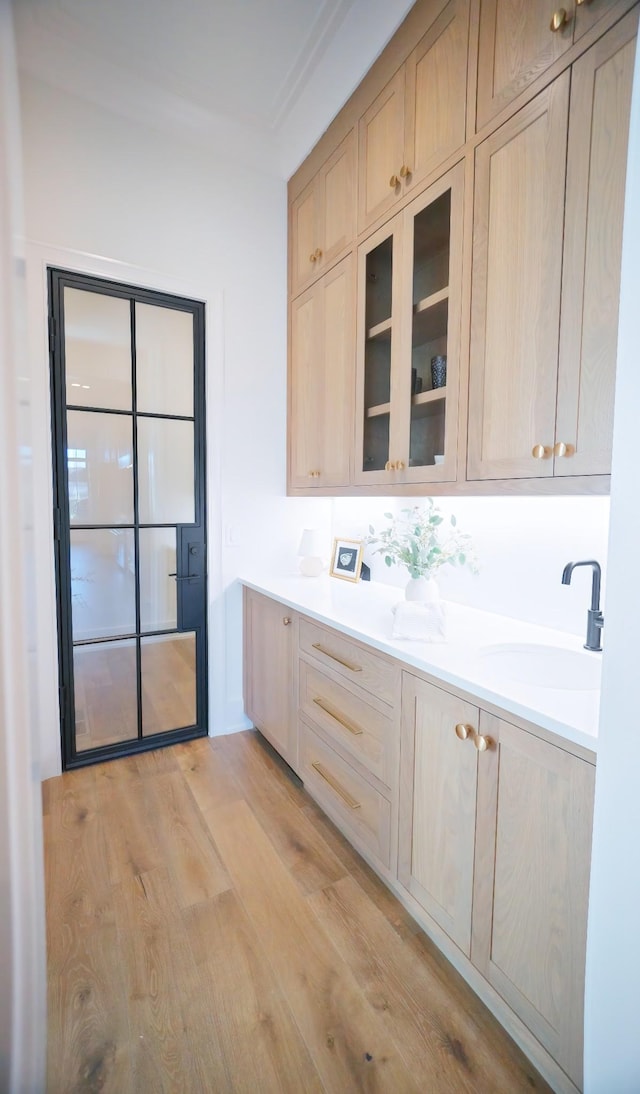 kitchen with sink, light brown cabinets, and light hardwood / wood-style floors