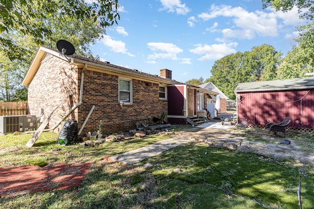 back of house featuring a yard and central AC