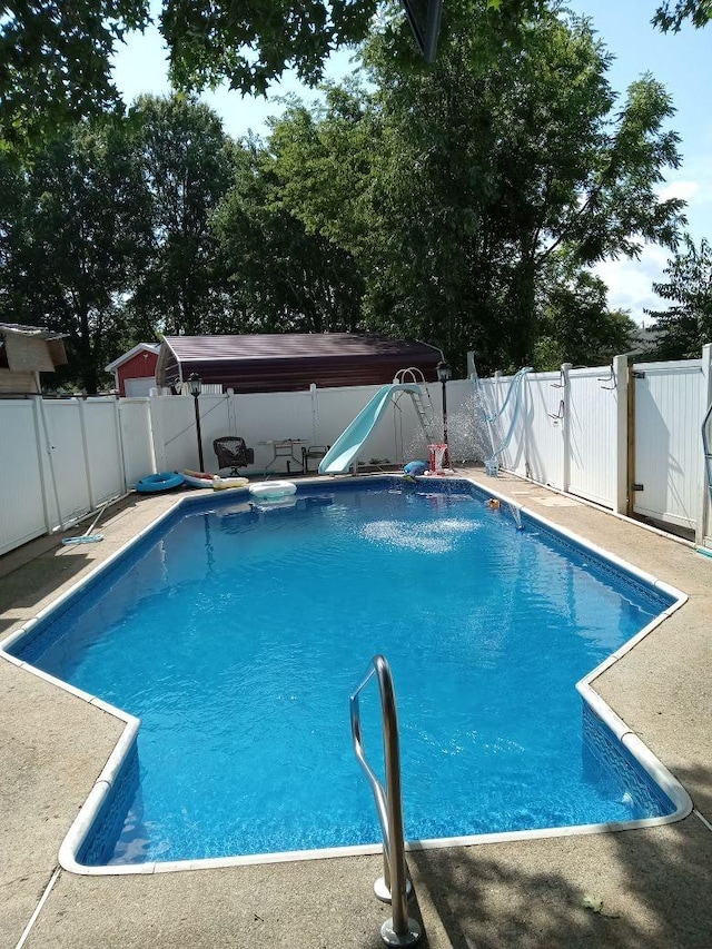 view of swimming pool featuring a jacuzzi and a water slide