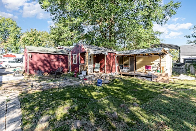 view of front of home with an outdoor structure and a front lawn