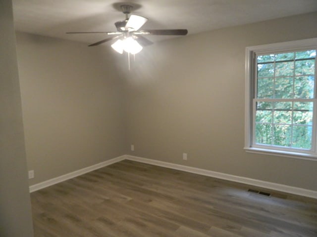 spare room with dark wood-type flooring and ceiling fan