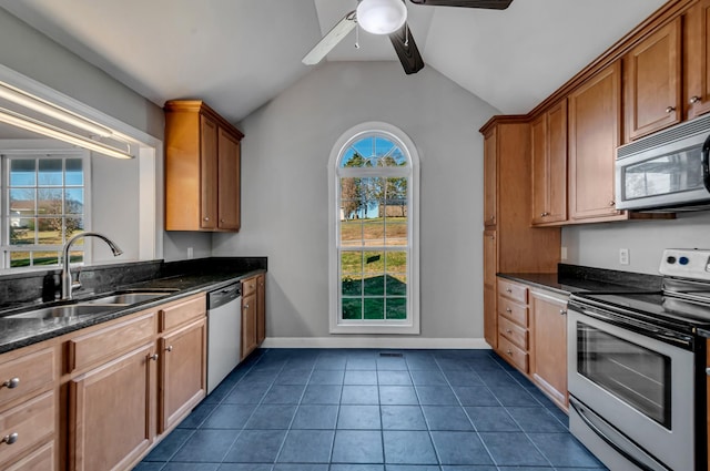 kitchen with appliances with stainless steel finishes, ceiling fan, sink, dark tile patterned flooring, and vaulted ceiling with beams