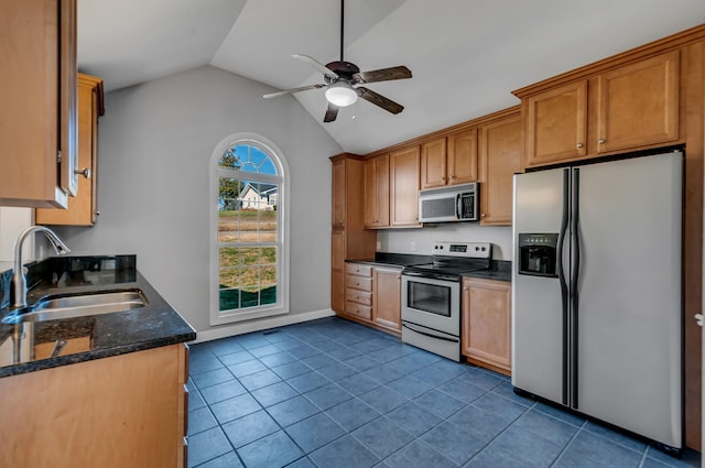 kitchen featuring appliances with stainless steel finishes, vaulted ceiling, ceiling fan, sink, and dark tile patterned flooring